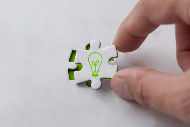Idea concept, hand holding last puzzle piece. Light bulb on top of last piece.