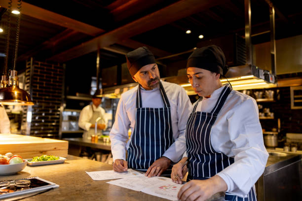 Team of Latin American cooks working at a restaurant and discussing the menu - food and drink establishment